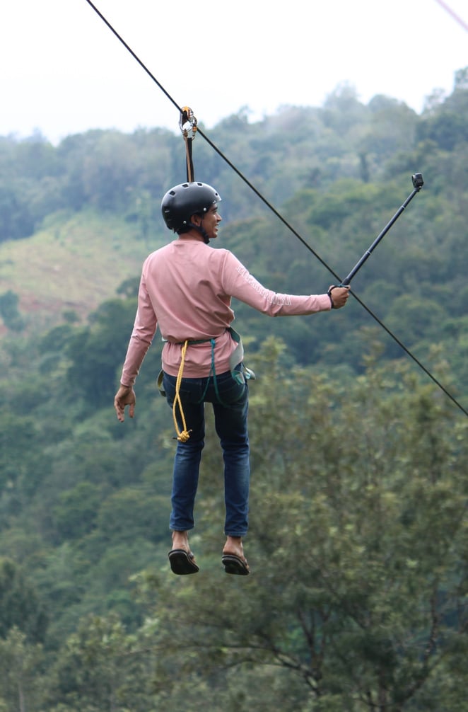 A Man Taking Selfie while Riding on a Zipline